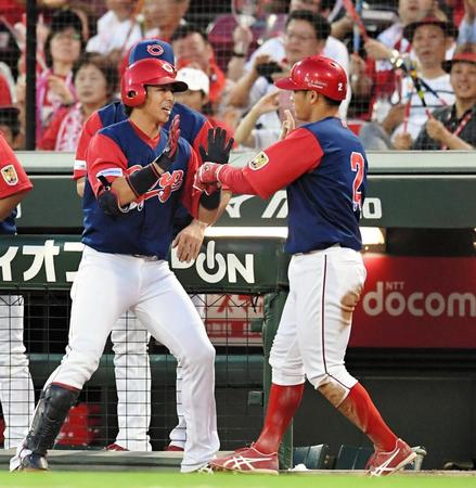 ２回、犠飛を放った広島・野間（左）は生還した田中とハイタッチを交わす＝マツダスタジアム
