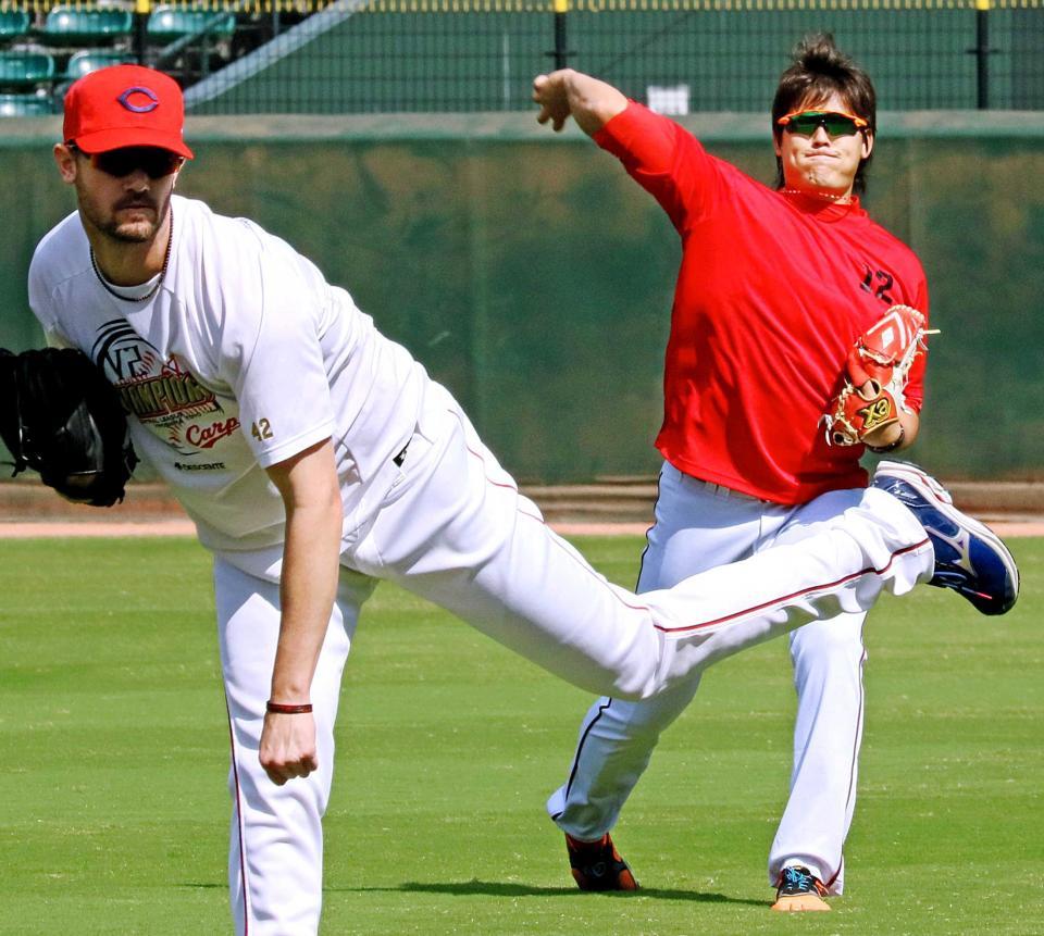 投手指名練習に参加し、キャッチボールをする（左から）ジョンソンと九里　