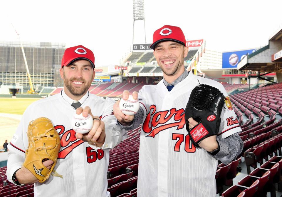 　ユニホームに袖を通しポーズを決めるローレンス（右）とレグナルト（撮影・飯室逸平）