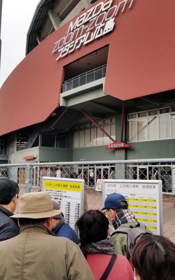 抽選券の当選番号が発表され、確認するファンたち