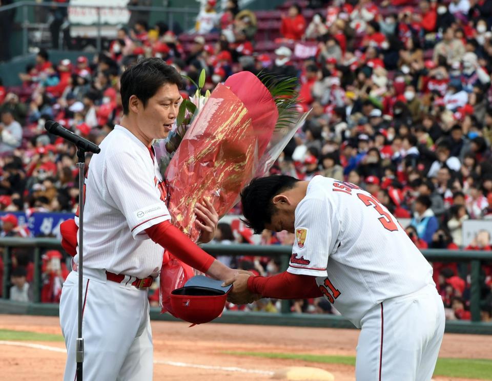 新井貴浩氏（左）は広島・石原慶幸から花束を贈られる＝マツダスタジアム（撮影・山口登）