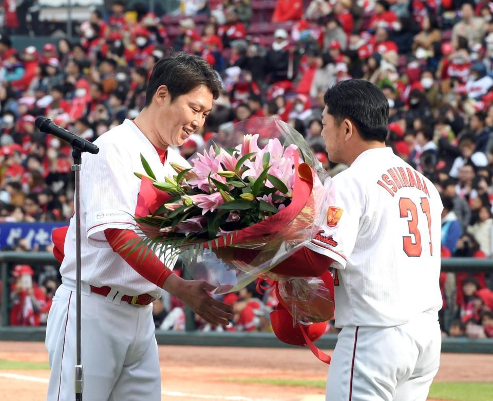 新井貴浩氏（左）は広島・石原慶幸から花束を贈られる＝マツダスタジアム（撮影・山口登）
