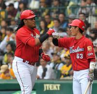 ６回、ソロを放った広島　サビエル・バティスタは広島・西川龍馬（右）とタッチを交わす＝甲子園（撮影・北村雅宏）