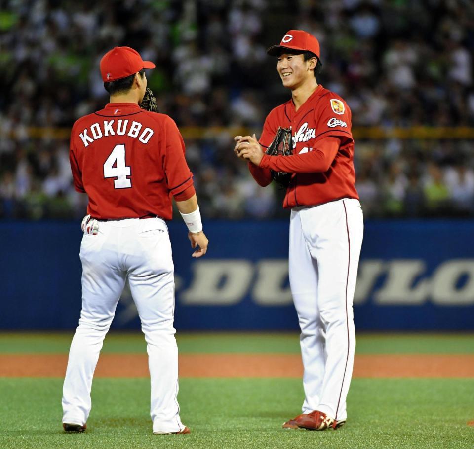 ７回、ノーヒットノーランがなくなり、広島・小窪哲也の激励に笑顔を見せる広島・山口翔（右）＝神宮（撮影・出月俊成）