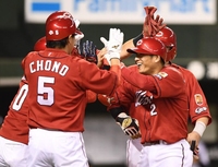 ８回、右越え満塁弾を放ち長野らナインに祝福される広島・田中広輔（右）＝メットライフドーム（撮影・園田高夫）