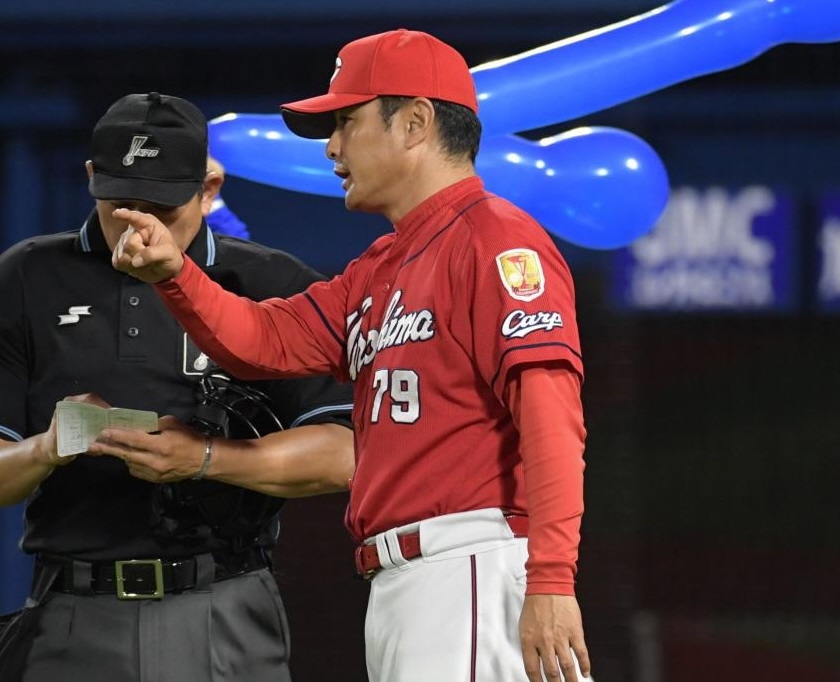 渋い表情で選手交代を告げる広島・緒方孝市監督＝横浜スタジアム（撮影・金田祐二）