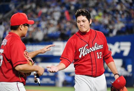 ６回、無失点に抑え、松山竜平（左）とタッチする広島・九里亜蓮＝横浜スタジアム（撮影・西岡正）