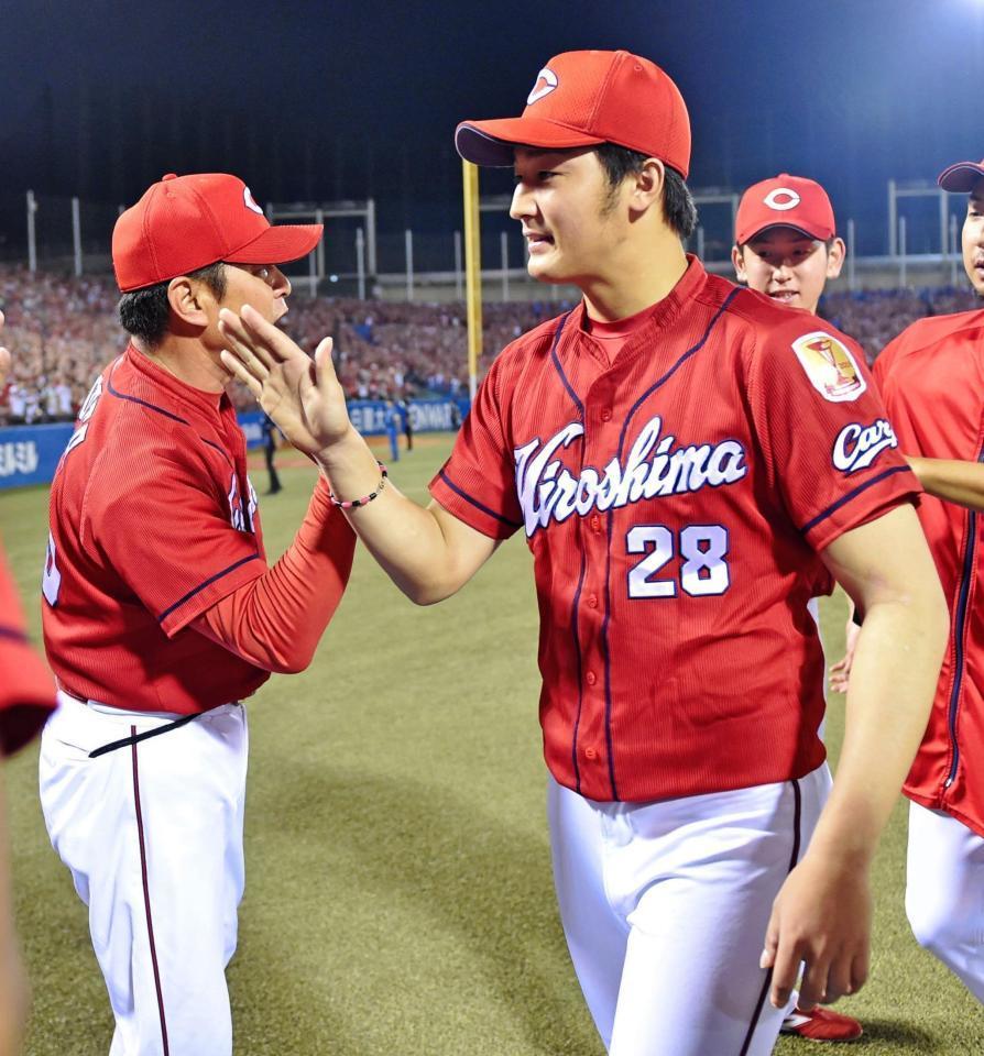 　６勝目を挙げ、緒方監督（左）とタッチを交わす床田