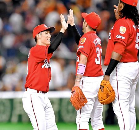 　巨人に勝利し、菊池涼とタッチを交わす西川（左）