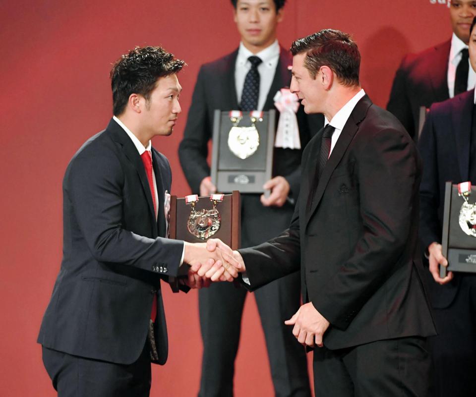 ベストナインを受賞し、トンプソン・ルーク（右）に祝福される広島・鈴木誠也＝東京都港区のグランドプリンスホテル新高輪（撮影・出月俊成）