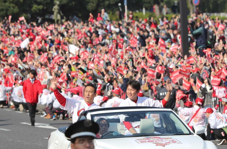 　カープの優勝パレードでファン、県民の歓声に応える黒田（左）と新井＝２０１６年１１月