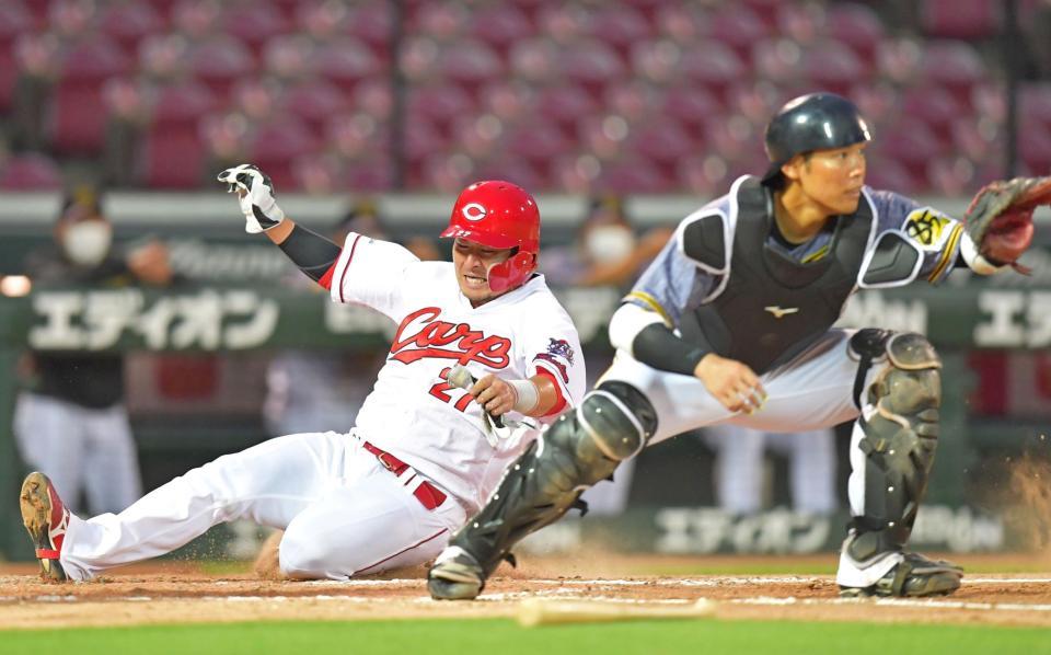 　阪神戦の５回、田中広の適時二塁打で生還する一走・会沢。右は捕手・原口＝マツダスタジアム