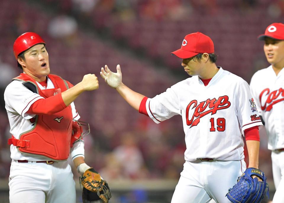 　５回、ロペスを併殺打に打ち取り、磯村（左）とタッチを交わす野村（撮影・立川洋一郎）