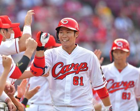 　１回、３ランを放ち、ナインの出迎えに笑顔を見せる坂倉  