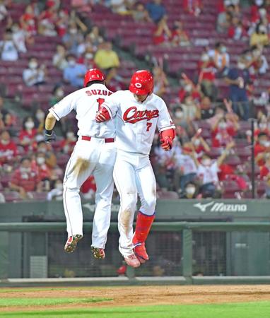 　４回、２ランを放って生還し広島・鈴木誠（左）とヒップタッチをする広島・堂林（撮影・立川洋一郎）