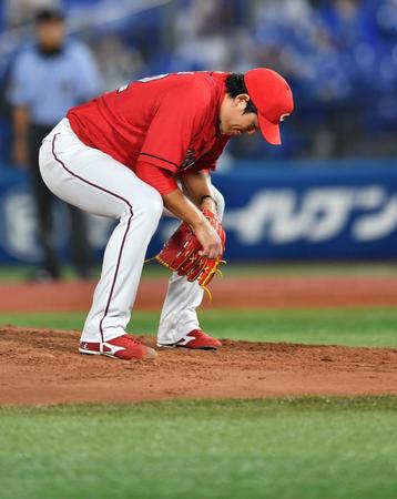 　４回、神里に四球を与えてピンチを広げ、しゃがみ込む広島・九里＝横浜スタジアム（撮影・西岡正）