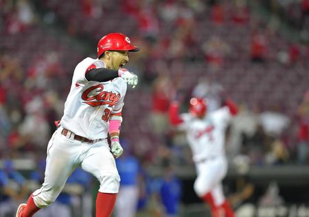 　９回、右前へ同点に追いつく２点適時打を放ち、ガッツポーズを見せる菊池涼。右は生還する田中