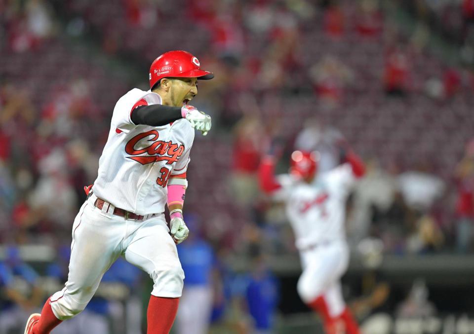 　９回、右前へ同点に追いつく２点適時打を放ち、ガッツポーズを見せる菊池涼。右は生還する田中