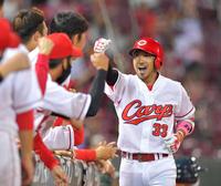 ３回、左中間スタンドへソロを放って生還し、出迎えるナインにガッツポーズを見せる菊池涼（撮影・立川洋一郎）