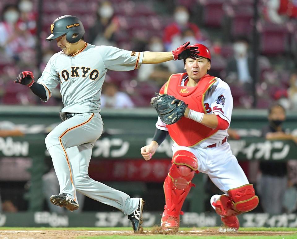 ９回表、本塁へ突入する巨人・増岡（左）をタッチアウトにする捕手・広島・会沢＝マツダスタジアム（撮影・立川洋一郎）