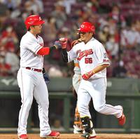 ４回、２ランを放って生還し、鈴木誠也（左）とタッチを交わす広島・松山＝マツダスタジアム（撮影・立川洋一郎）