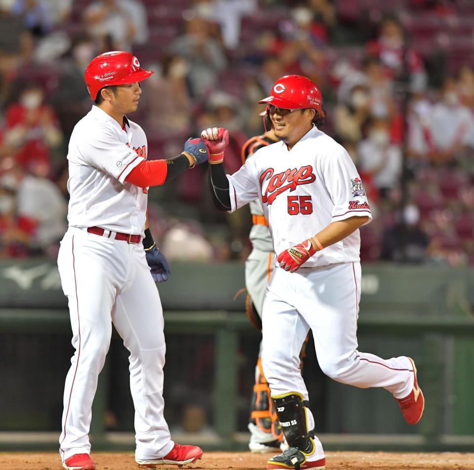 ４回、２ランを放って生還し、鈴木誠也（左）とタッチを交わす広島・松山＝マツダスタジアム（撮影・立川洋一郎）