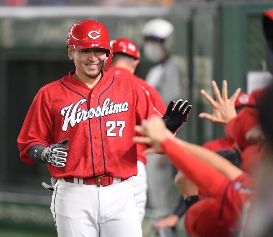 ２回、ソロを放ち、笑顔でナインに迎えられる広島・会沢（撮影・金田祐二）