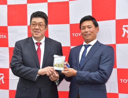 　指名あいさつを受け、広島・佐々岡真司監督（左）のサイン入りドラフト会議パスを手渡されて笑顔を見せるトヨタ自動車・栗林良吏＝豊田市、トヨタスポーツセンター（撮影・立川洋一郎）