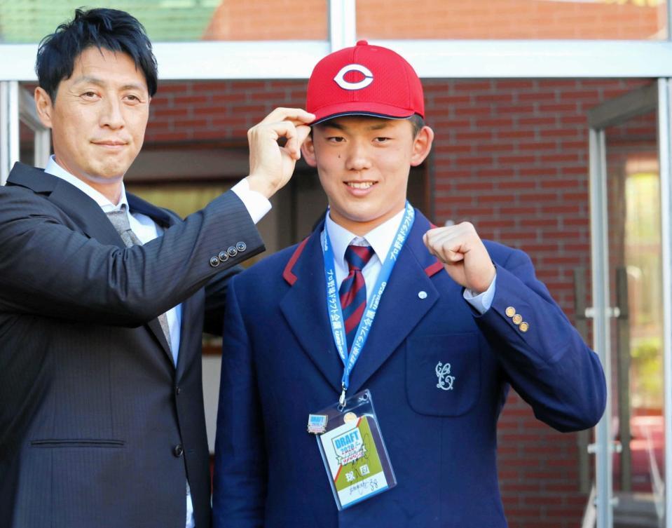 　広島・鞘師スカウト（左）から帽子を受け取り、笑顔を見せる智弁和歌山・小林（撮影・赤尾慶太）