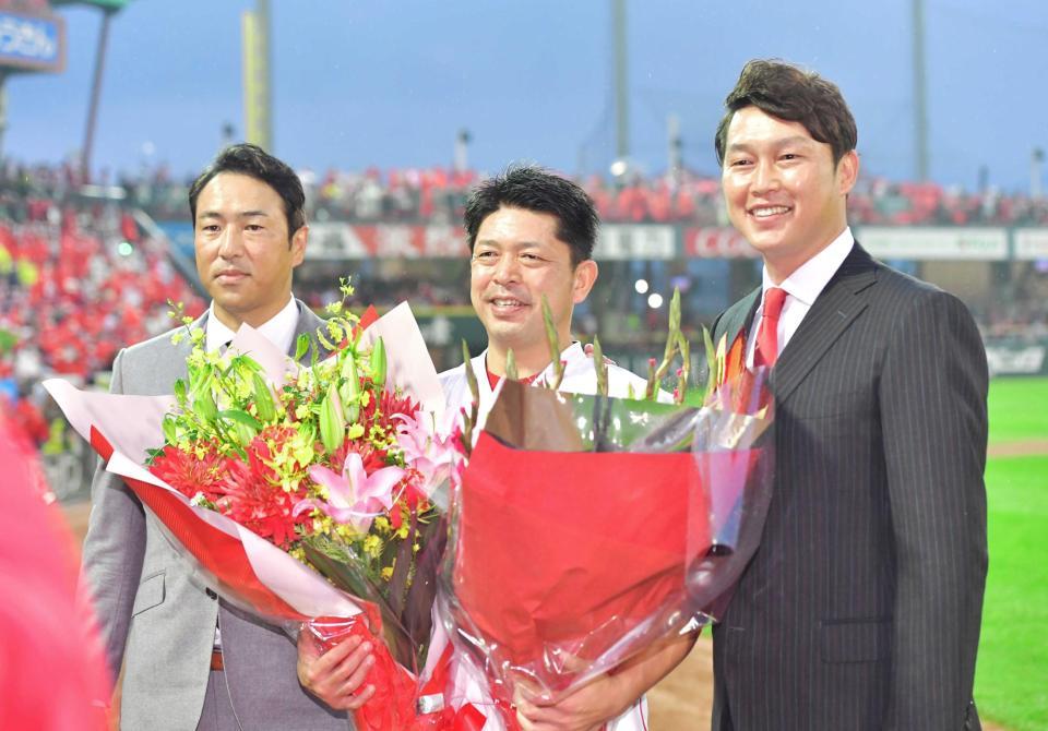 新井氏（右）と黒田氏（左）から花束を受け取り笑顔を見せる石原慶　