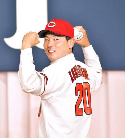 　新入団会見に臨みユニホームに袖を通した栗林（撮影・立川洋一郎）