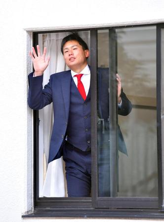 　入寮した１０４号室から手を振る栗林（撮影・立川洋一郎）