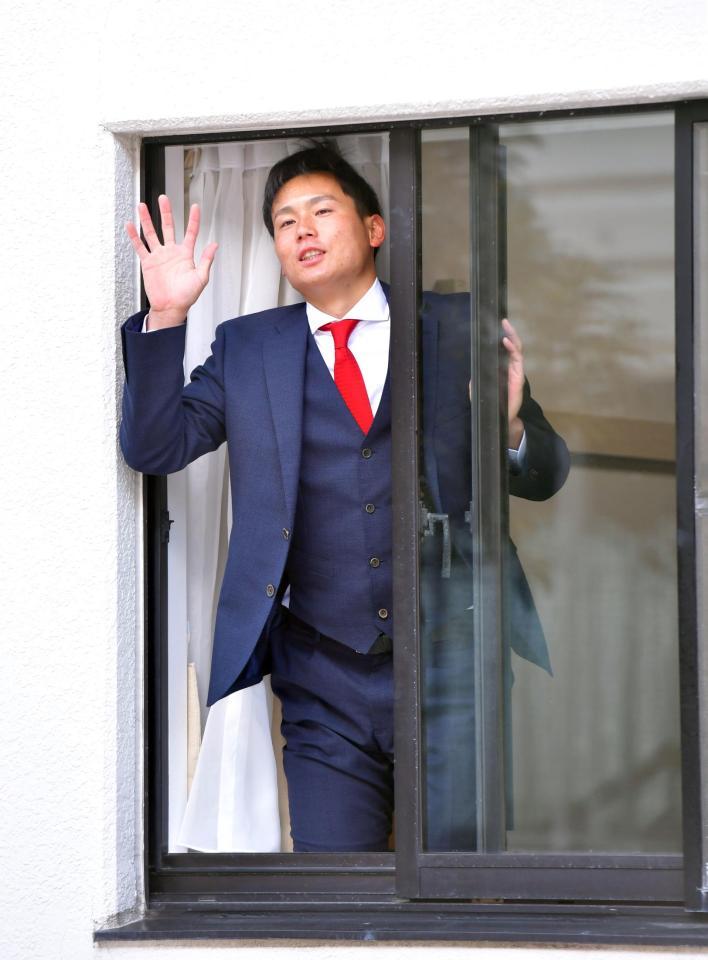 　入寮した１０４号室から手を振る栗林（撮影・立川洋一郎）