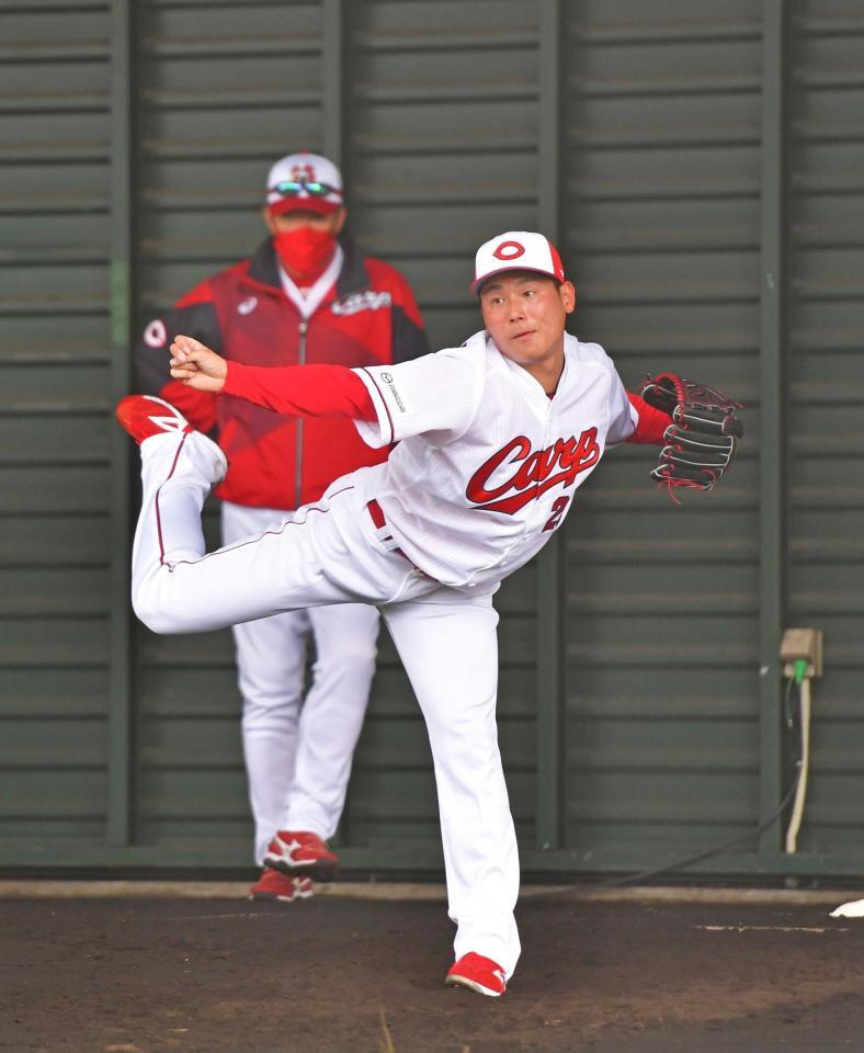 ブルペンで投げ込む栗林。後方は佐々岡監督（撮影・立川洋一郎）