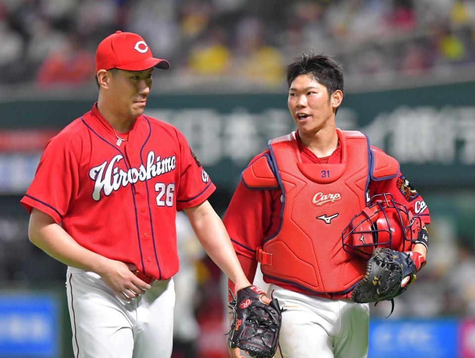 　８回裏を投げ終えた中田（左）と話をしながらベンチへ戻る坂倉