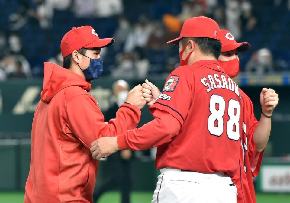 ３年ぶりに勝利投手となり、佐々岡真司監督（右）から祝福される広島・高橋昂也＝東京ドーム（撮影・佐藤厚）