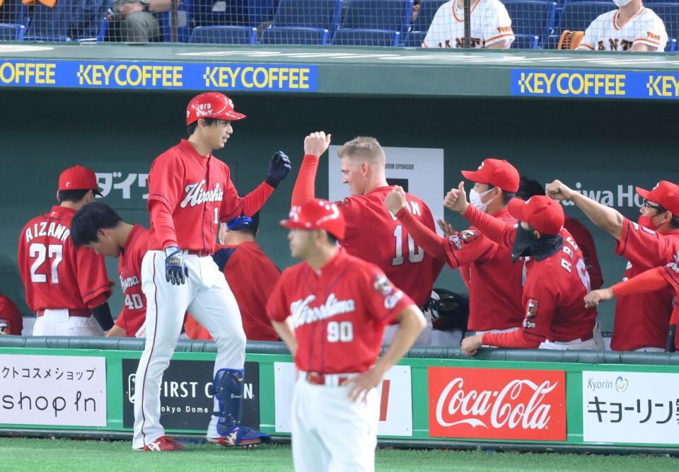 ４回、犠打を決めて迎えられる広島・野村＝東京ドーム（撮影・堀内翔）