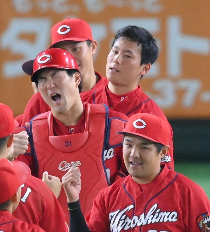 今シーズン８セーブ目を挙げてタッチを交わす広島・栗林＝東京ドーム（撮影・堀内翔）