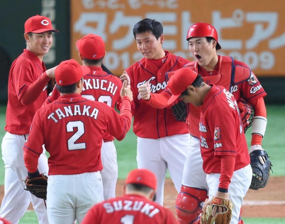 　８セーブ目を挙げてタッチを交わす栗林（中央）