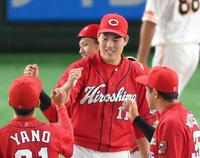 　完投勝利を挙げてタッチを交わす九里（撮影・堀内翔）