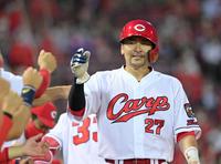 　４回、宇草の二ゴロで生還しナインの出迎えを受ける会沢（撮影・立川洋一郎）