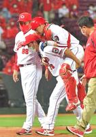 　８回、栗山の三ゴロからの挟殺プレーで脚を負傷し、背負われて引き揚げる会沢。左は佐々岡監督（１５日）