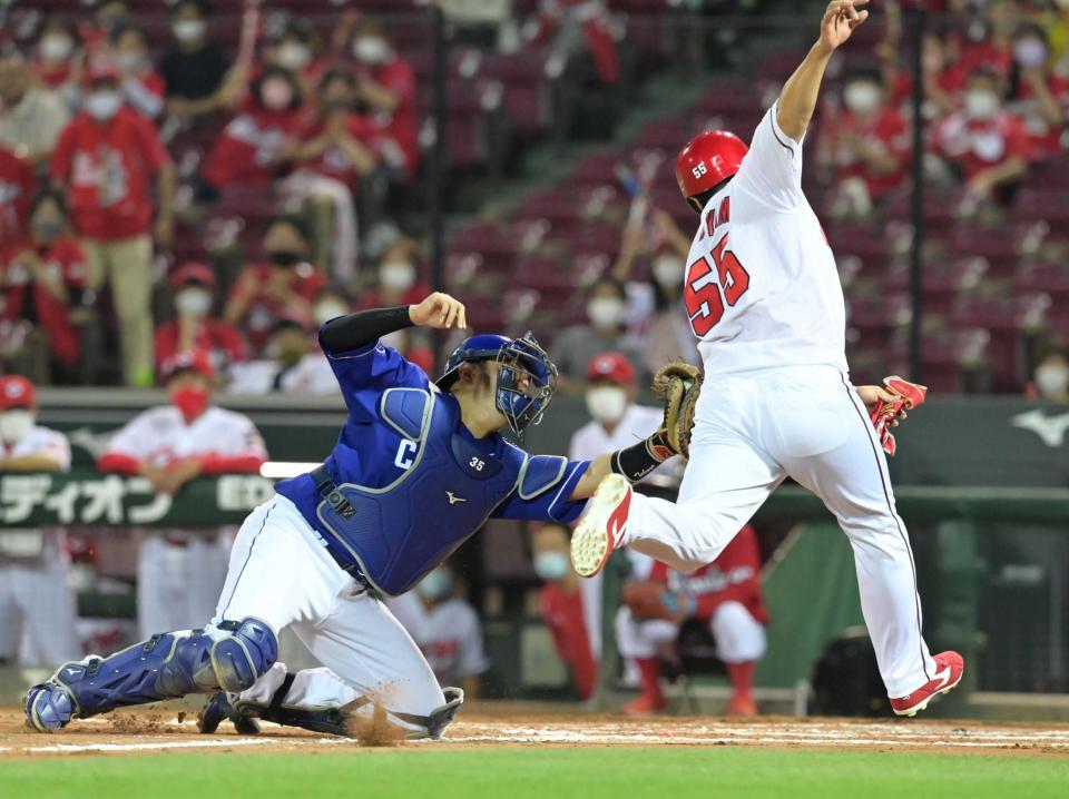 　９回、小園の左前打で本塁を突くもタッチアウトになる二走・松山。左は捕手・木下（撮影・立川洋一郎）