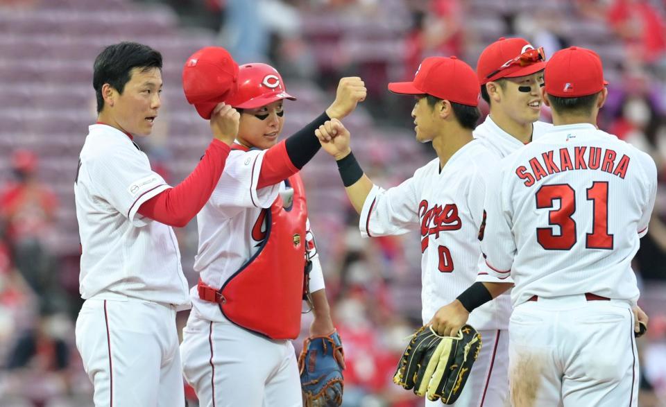 　９回を三者凡退で締めくくり、ナインと勝利を喜ぶ広島・栗林（撮影・立川洋一郎）