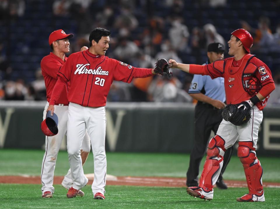 　９回、梶谷を二ゴロに打ち取り磯村（右）とタッチを交わす栗林（撮影・開出牧）