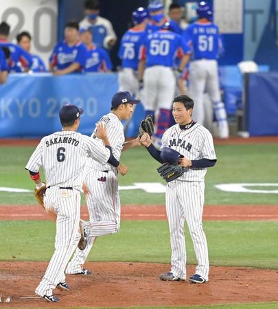 　韓国戦の最後を締め、坂本（６）らとタッチを交わす栗林（右手前）＝撮影・高部洋祐