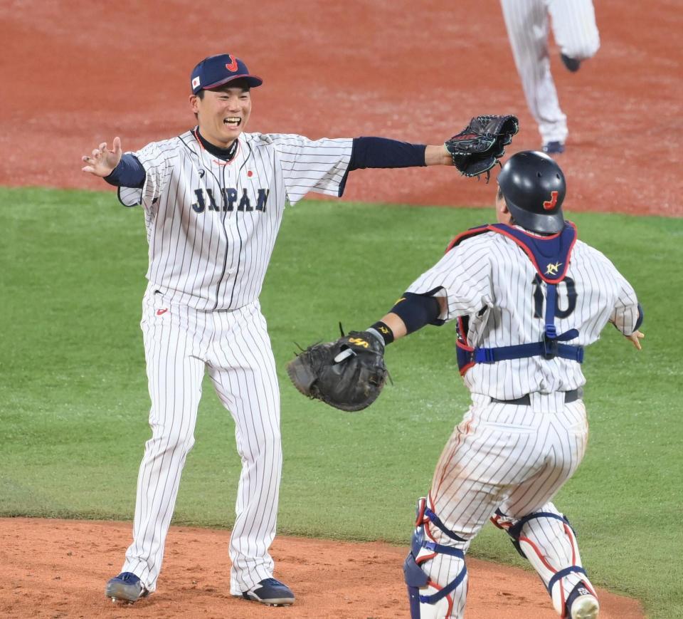 　優勝を決めて甲斐拓也と抱き合う栗林良吏＝７日