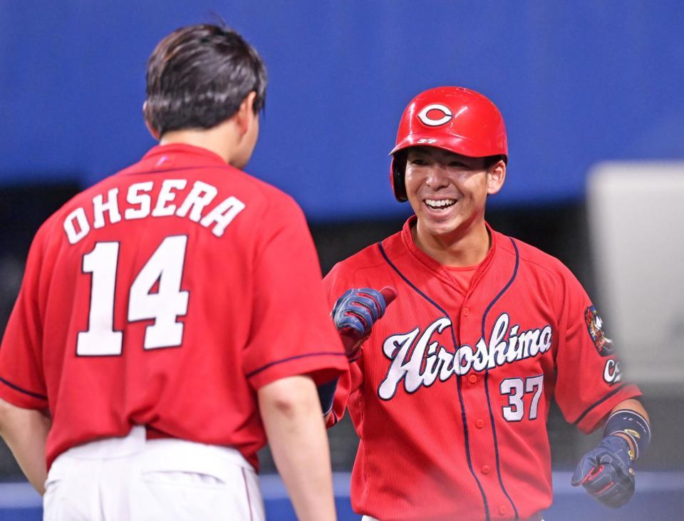 　７回、長野の適時打で生還し、出迎えた大瀬良（左）に笑顔を見せる野間（撮影・立川洋一郎）