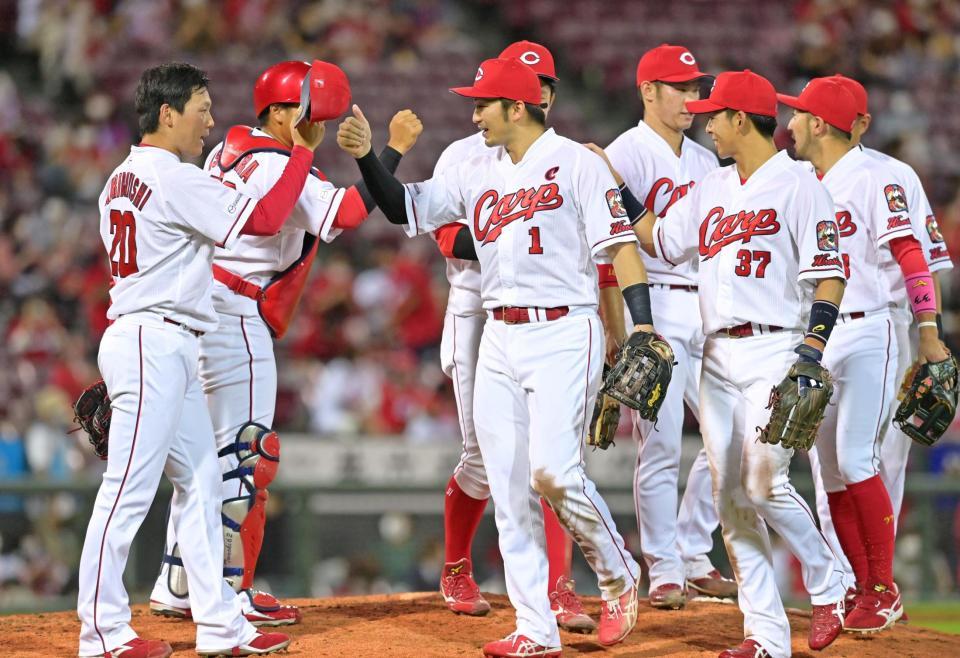 　最後を締めくくった栗林（左）とタッチを交わす広島ナイン（撮影・立川洋一郎）