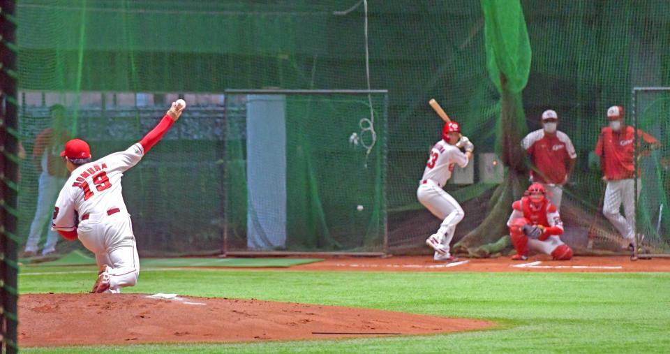 　試合中止が決定した後、室内練習場で打者を相手に投げ込む野村（１９）。右奥は投球を見守る佐々岡監督（撮影・立川洋一郎）